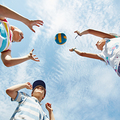 Friendly kids playing volleyball outdoors