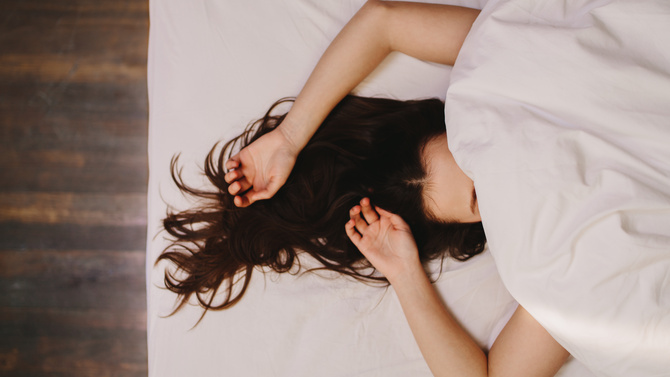 Woman sleeping on bed / Jacob Ammentorp Lund, Jacob Lund - stock.adobe.com Top view of a woman sleeping on bed covering her face. Close up of a woman in deep sleep with her hand beside her head and hair let loose.