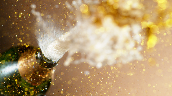 Champagne explosion, freeze motion of flying wine splashes. Celebrating concept, happy New Year theme.