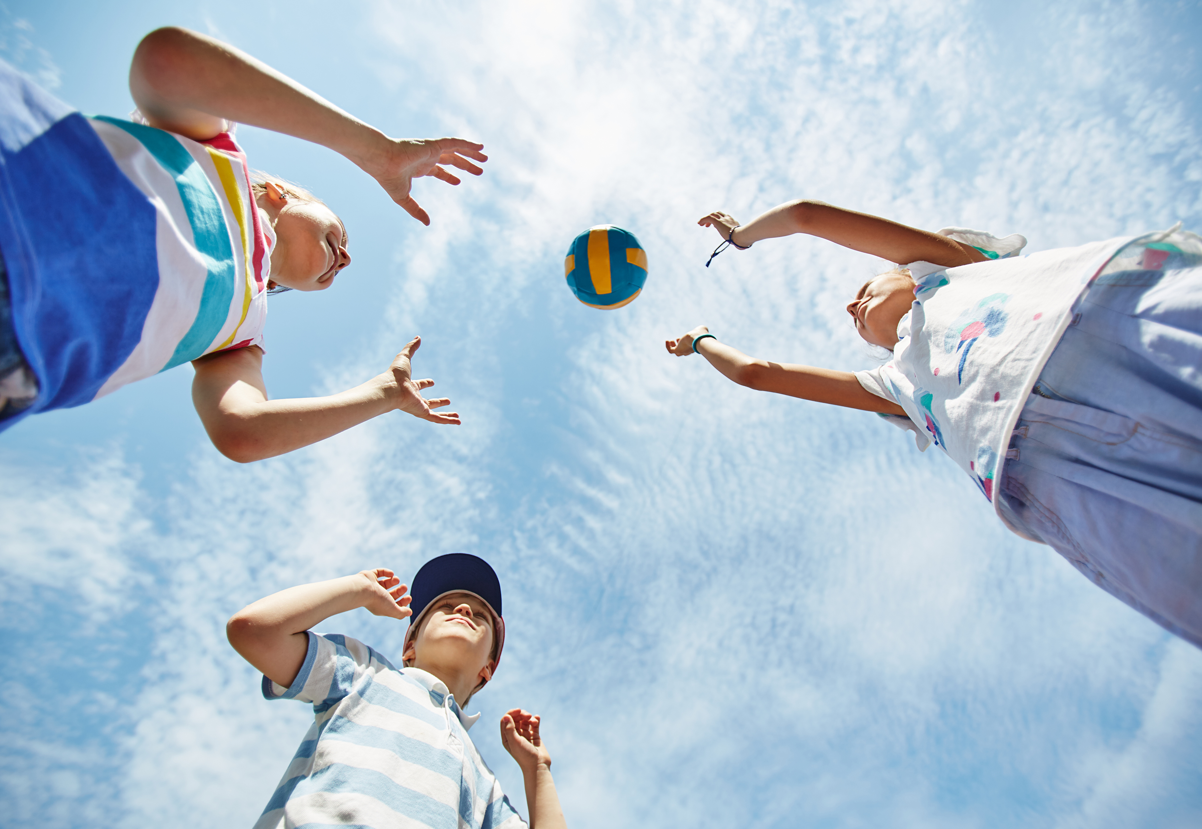 Friendly kids playing volleyball outdoors