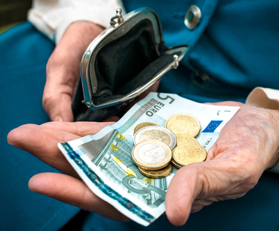 elderly caucasian woman counting coins in her hands