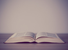 An opened holy bible on a wooden table