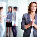 Image of pretty business leader looking at camera with interacting partners at background