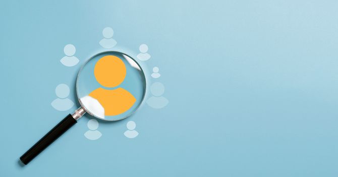 Yellow human icon inside of magnifier glass among white icons for customer focus and customer relation management or CRM concept.